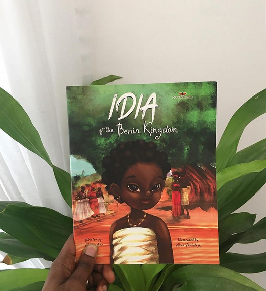 Book Idia of the Benin Kingdom held up in front of house plant